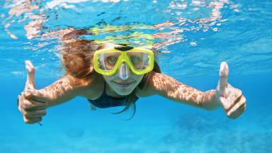 Young woman in snorkeling mask dive underwater with tropical fishes